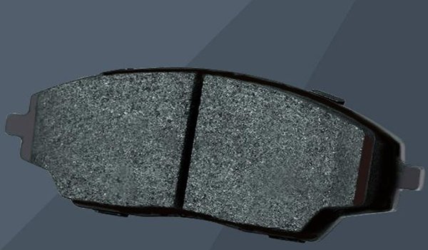 Bond the friction material to the backing plate using heat and pressure