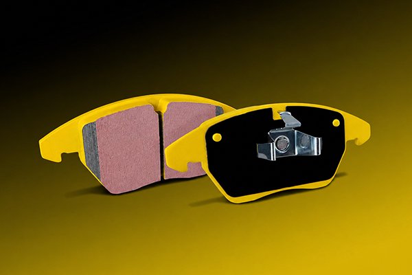 colored brake pads showing friction material and backing plate, illustrating that brake pad color relates to coating and branding rather than performance