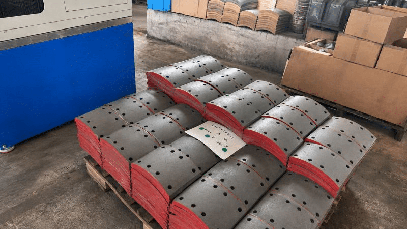 Drilled replacement brake linings for heavy-duty truck drum brakes stacked on a pallet